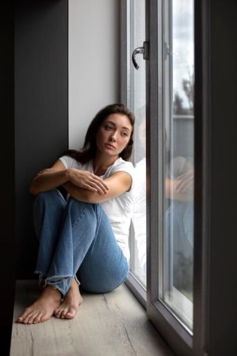 How to handle divorce stress Gracefully? - 01 12 portrait young woman with low self esteem sitting by window home 23 2150038983